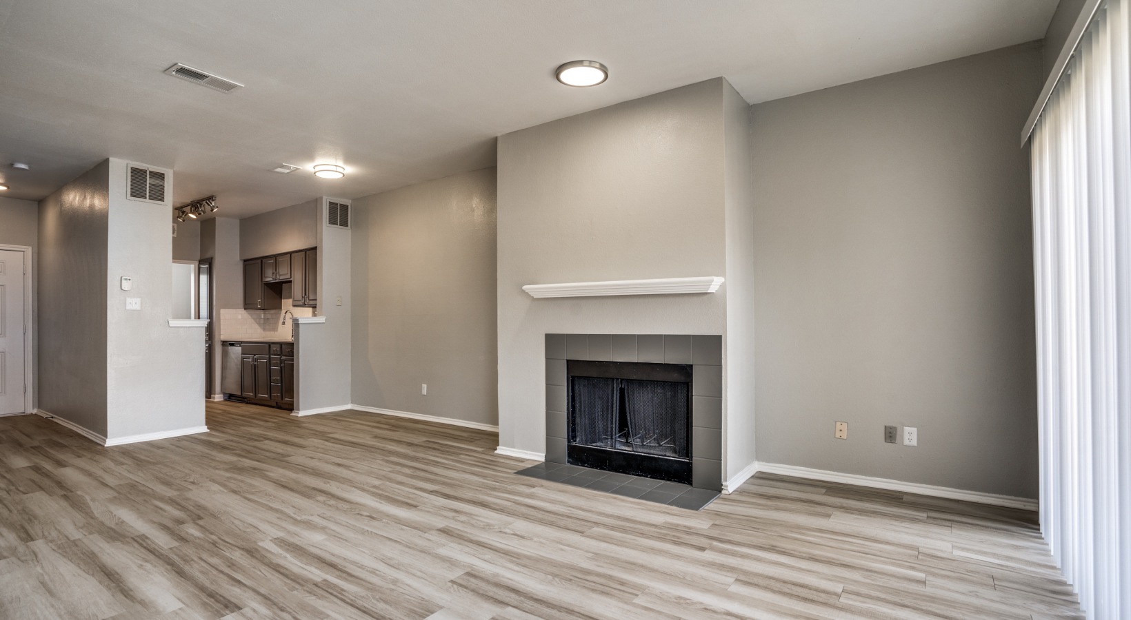 empty living room with fireplace and hardwood floors at The  Hathaway at Willow Bend