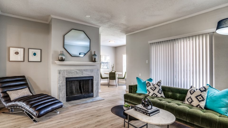 a living room with a fireplace and green couch at The  Hathaway at Willow Bend